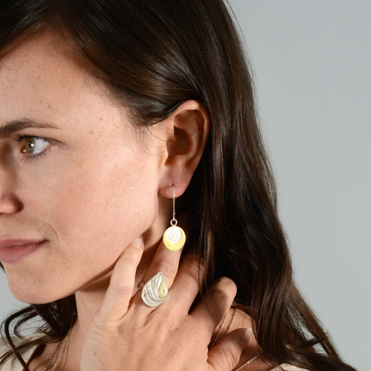 woman wearing silver earrings and silver ring