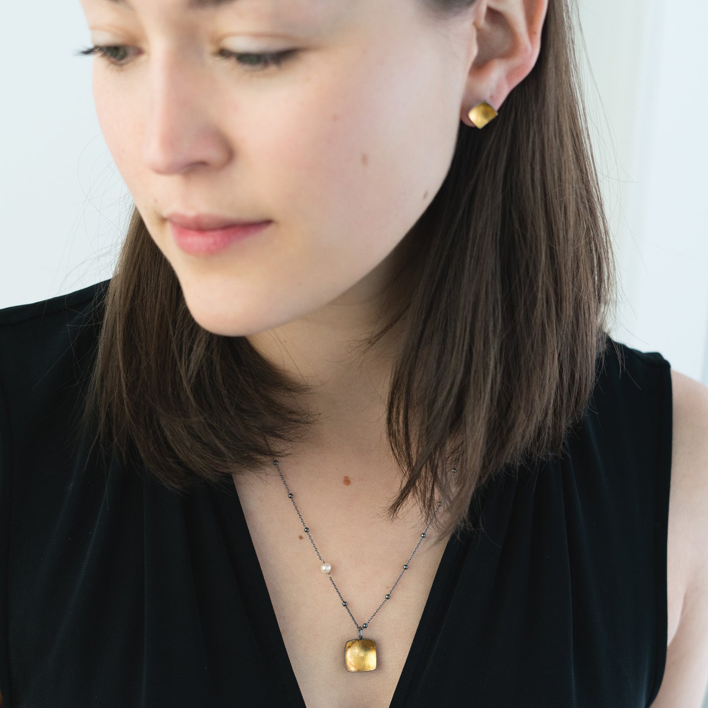 woman wearing oxidized silver and gold jewelry