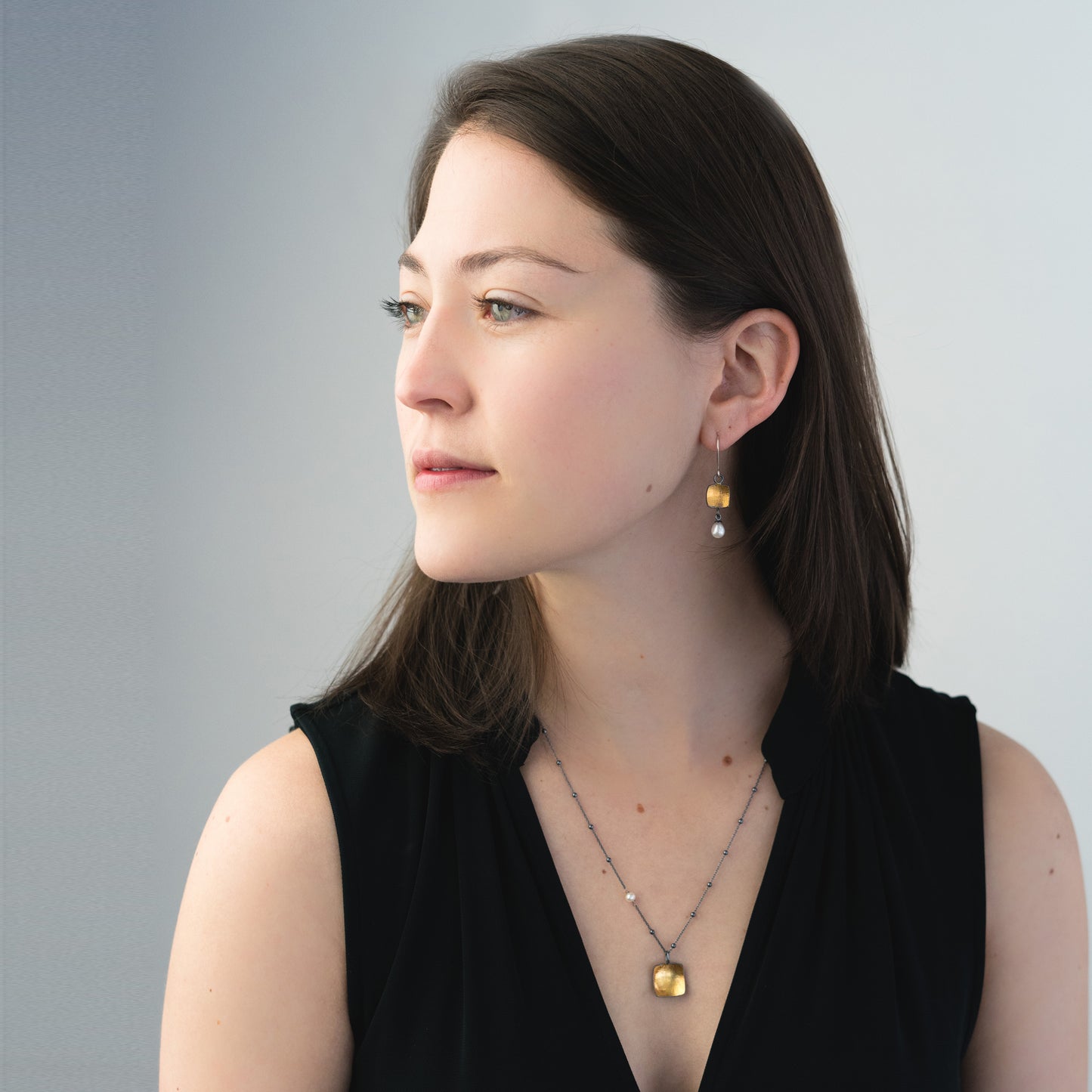 woman wearing oxidized silver and gold jewelry
