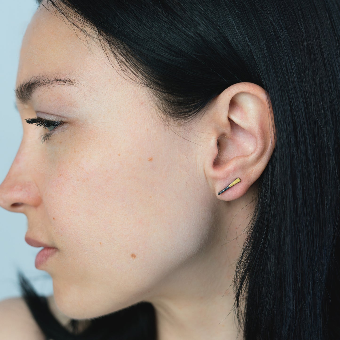 woman wearing oxidized silver and gold bar posts