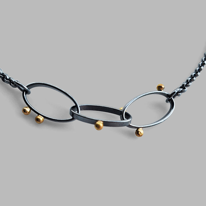three oval hoops links on chain with scattered gold dots