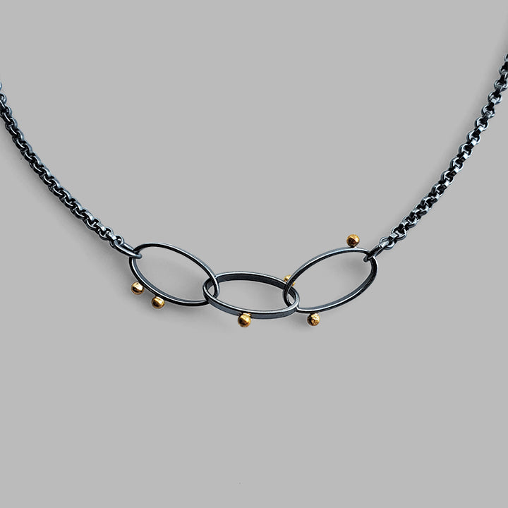 three oval hoops links on chain with scattered gold dots