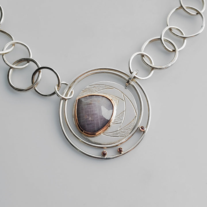 silver textured statement piece with pink teardrop rose cut gemstone and red accent stones