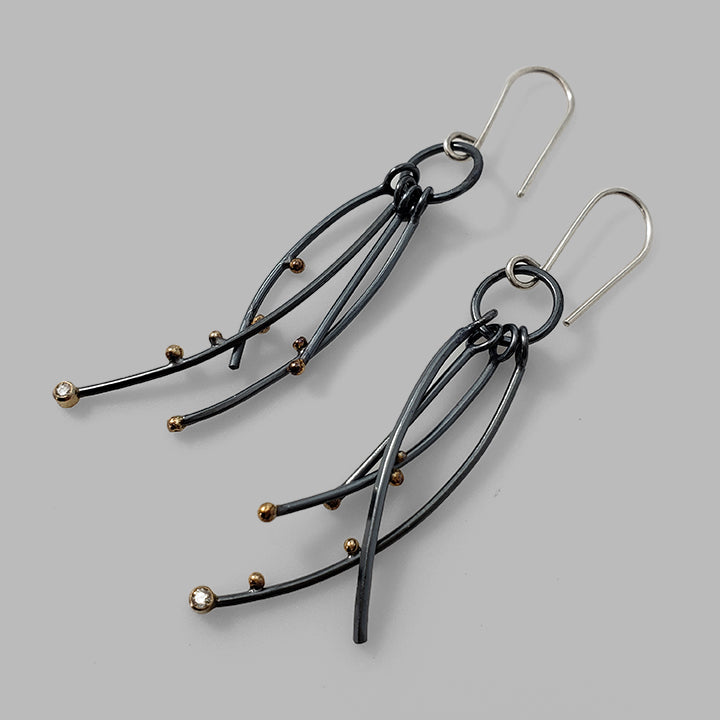 multiple oxidized silver curved wires with gold dots and gemstones dangles