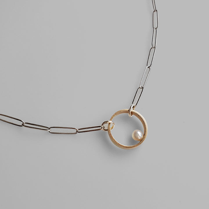 flat shiny linked chain with gold hoop holding fresh water pearl 