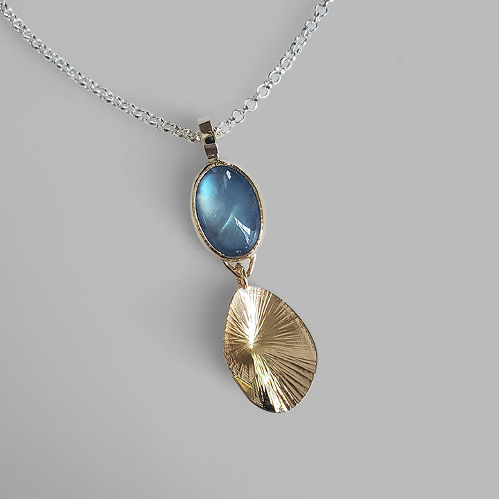 blue moonstone gem set in gold on silver chain with gold shell shaped charm