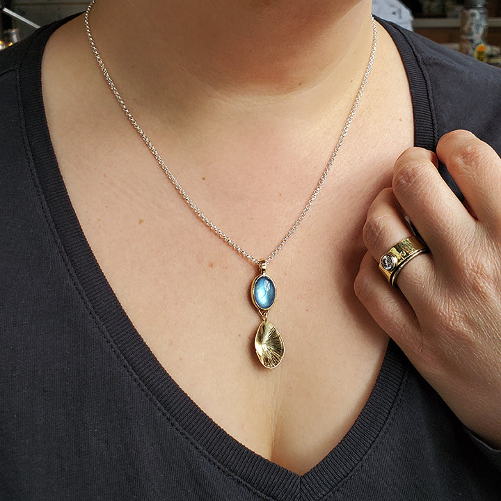 moonstone set in gold with textured dangle pendant shell shaped charm on chain