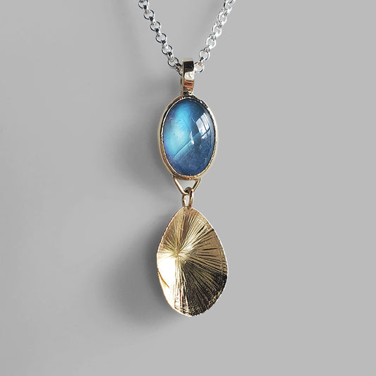blue moonstone set in gold with shell shaped gold charm on silver chain