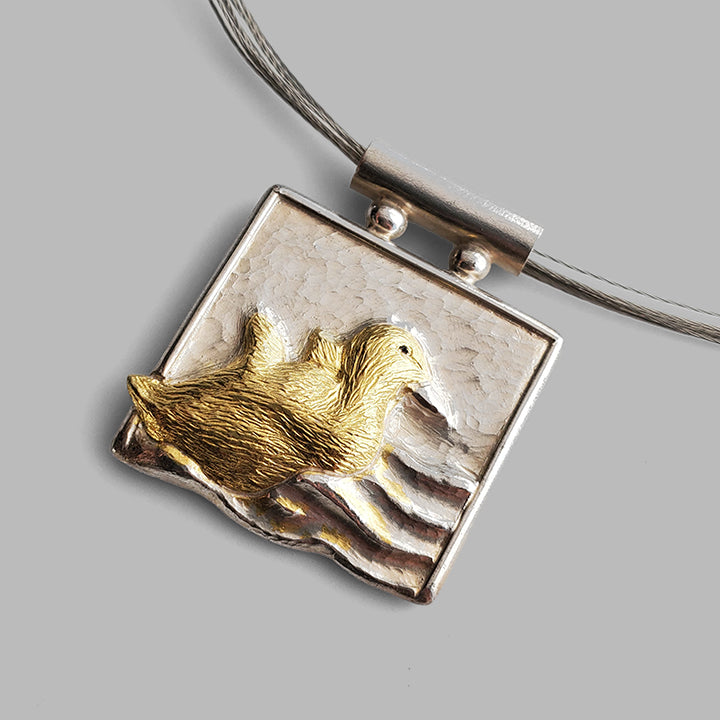 square silver pedant with baby bird in gold