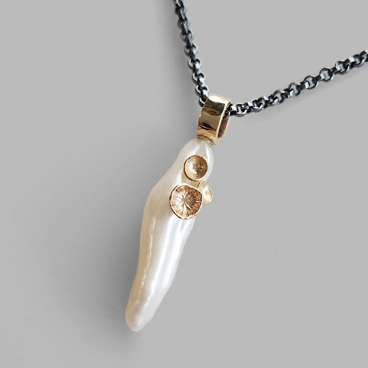 organic stick shaped pearl with gold cup accents on a long oxidized silver chain