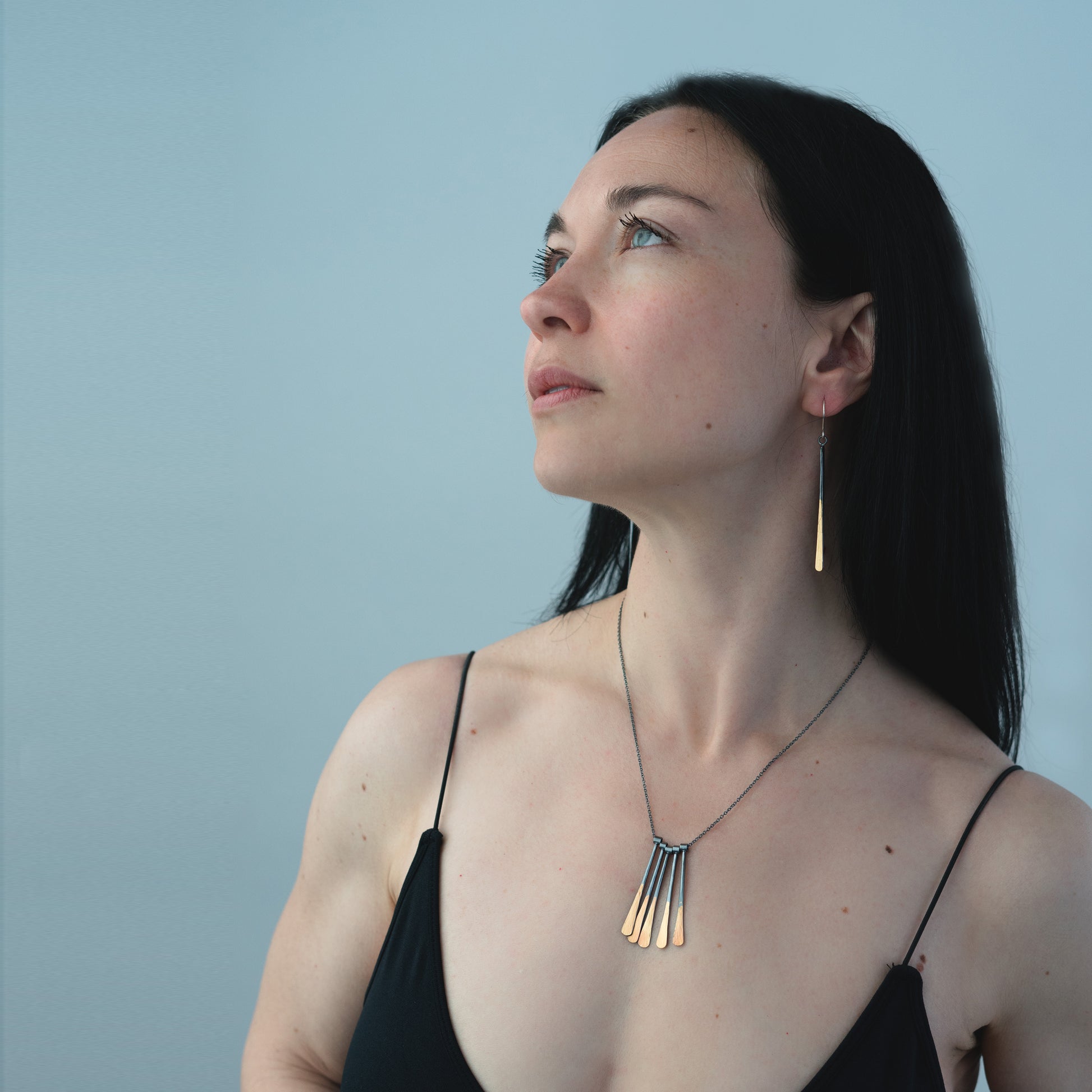 woman wearing oxidized silver and gold jewelry