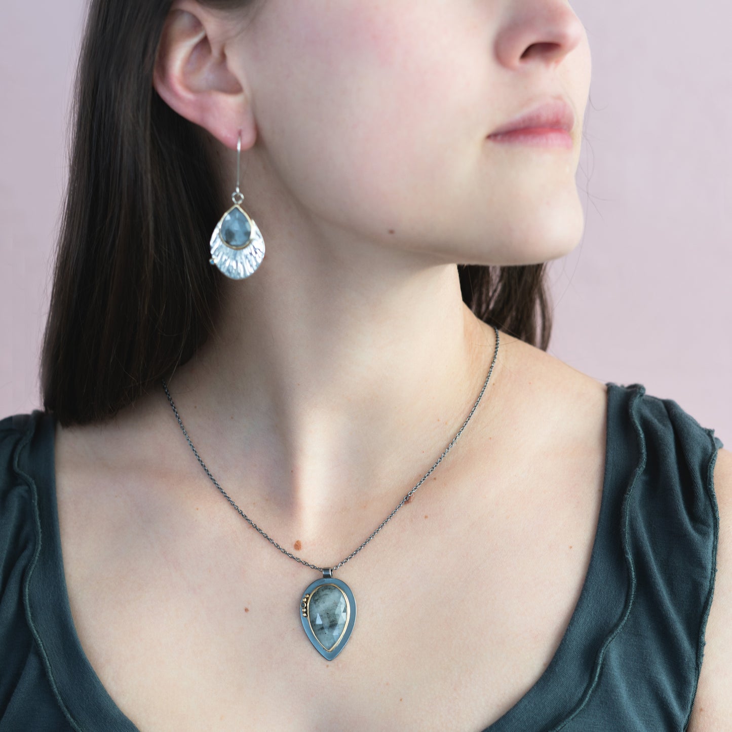woman wearing oxidized silver pendant with gold details 