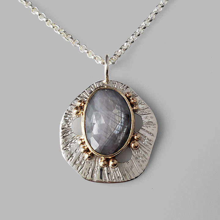 grey sapphire set in yellow gold on textured silver pendant with gold dots