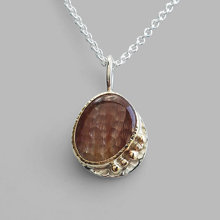 red striped clear stone set in gold on textured silver plate on silver chain