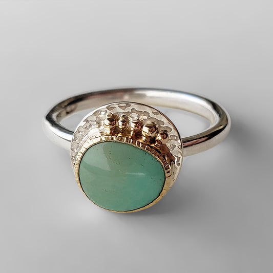 soft green stone set in textured gold bezel on silver plate with gold dots