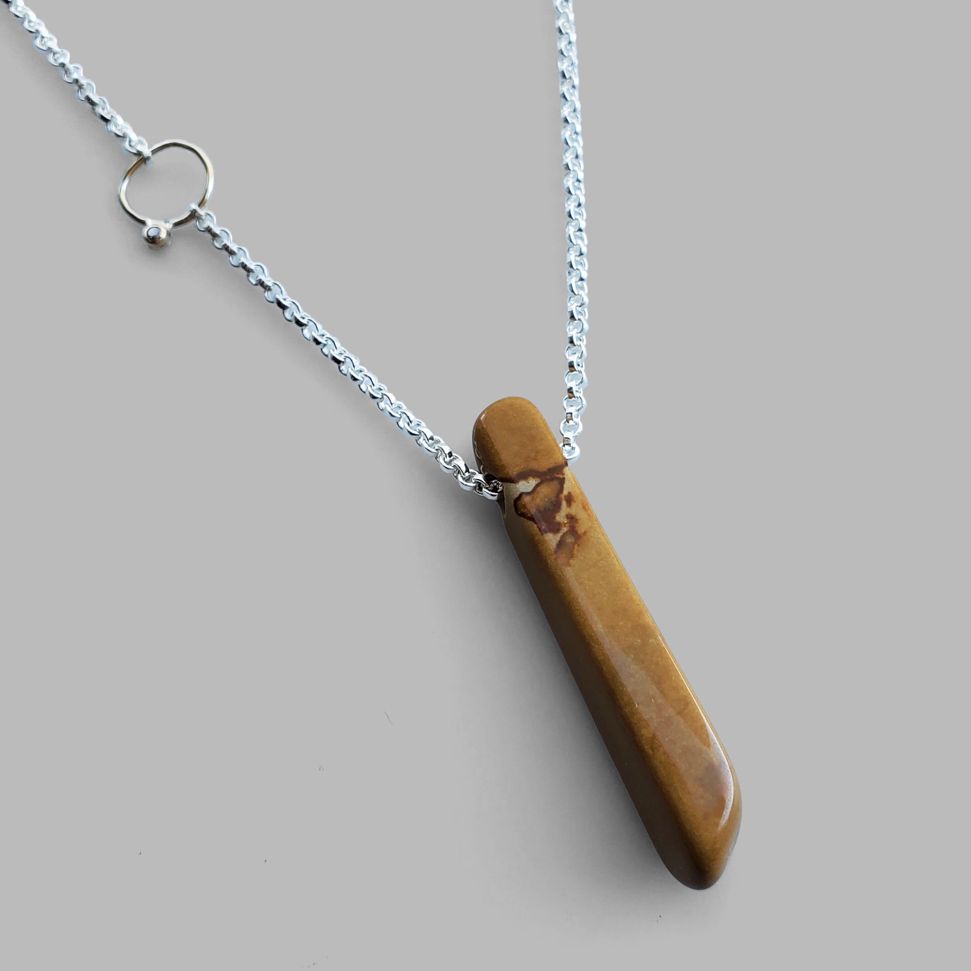 brown stick shaped stone on silver chain with diamond on gold hoop