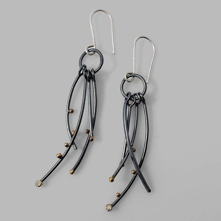 multiple oxidized silver curved wires with gold dots and gemstones dangles