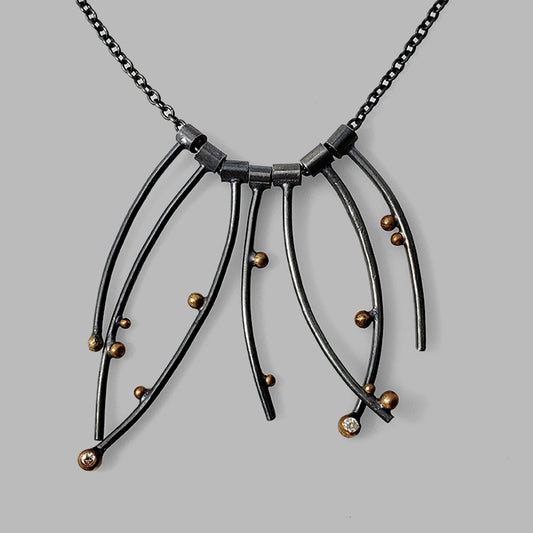 multiple curved oxidized silver wires with gold dots and gemstones on chain