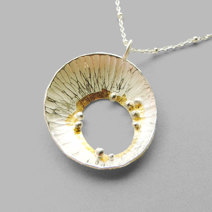 silver cup pendant with silver dots and gold accents