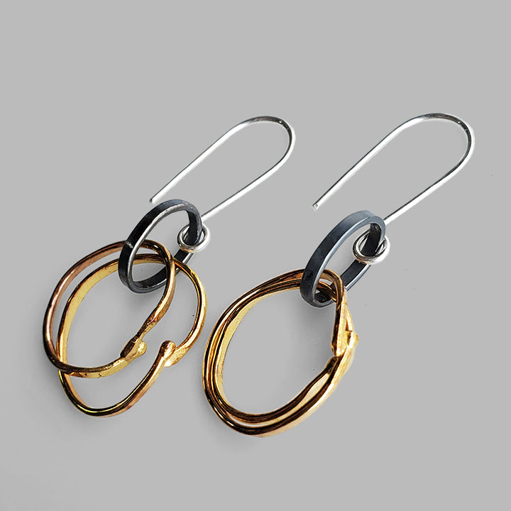 organic hammered gold hoops on oxidized silver oval hoop dangles