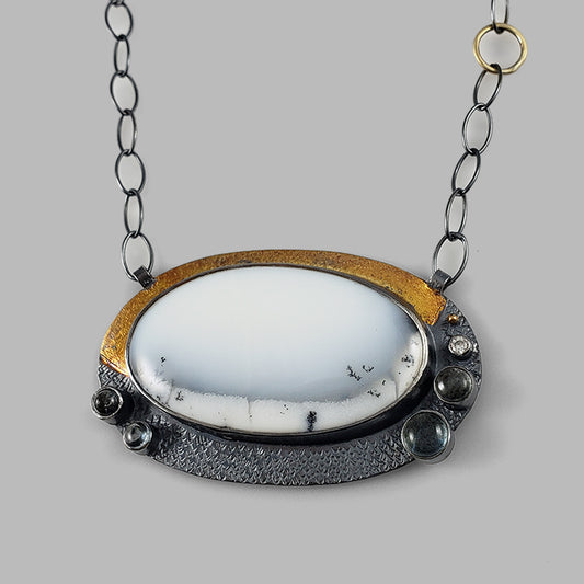 unique mixed metal oxidized silver and gold pendant with white and black stone with blue stone accents