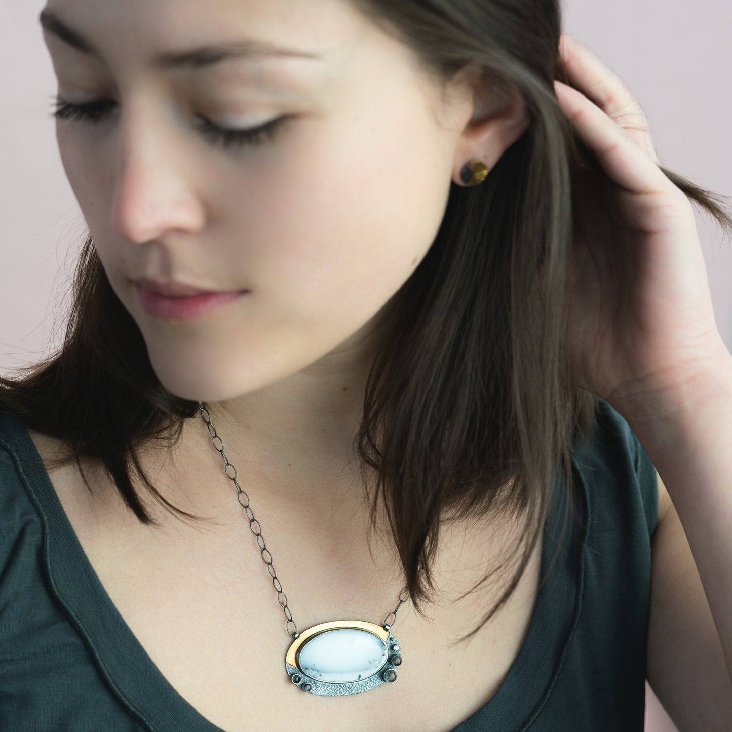 woman wearing white gemstone mixed metal statement necklace