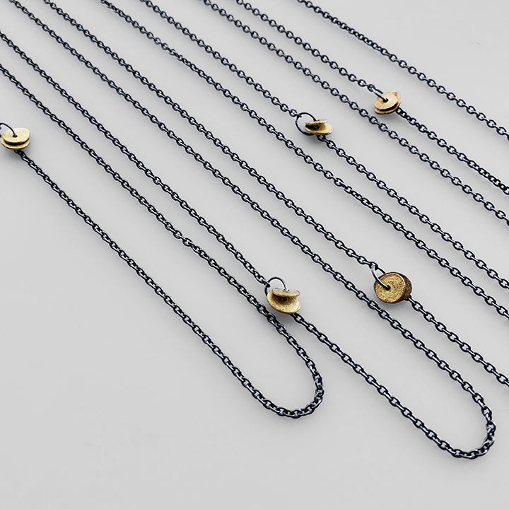 short and long oxidized silver chains with gold charms