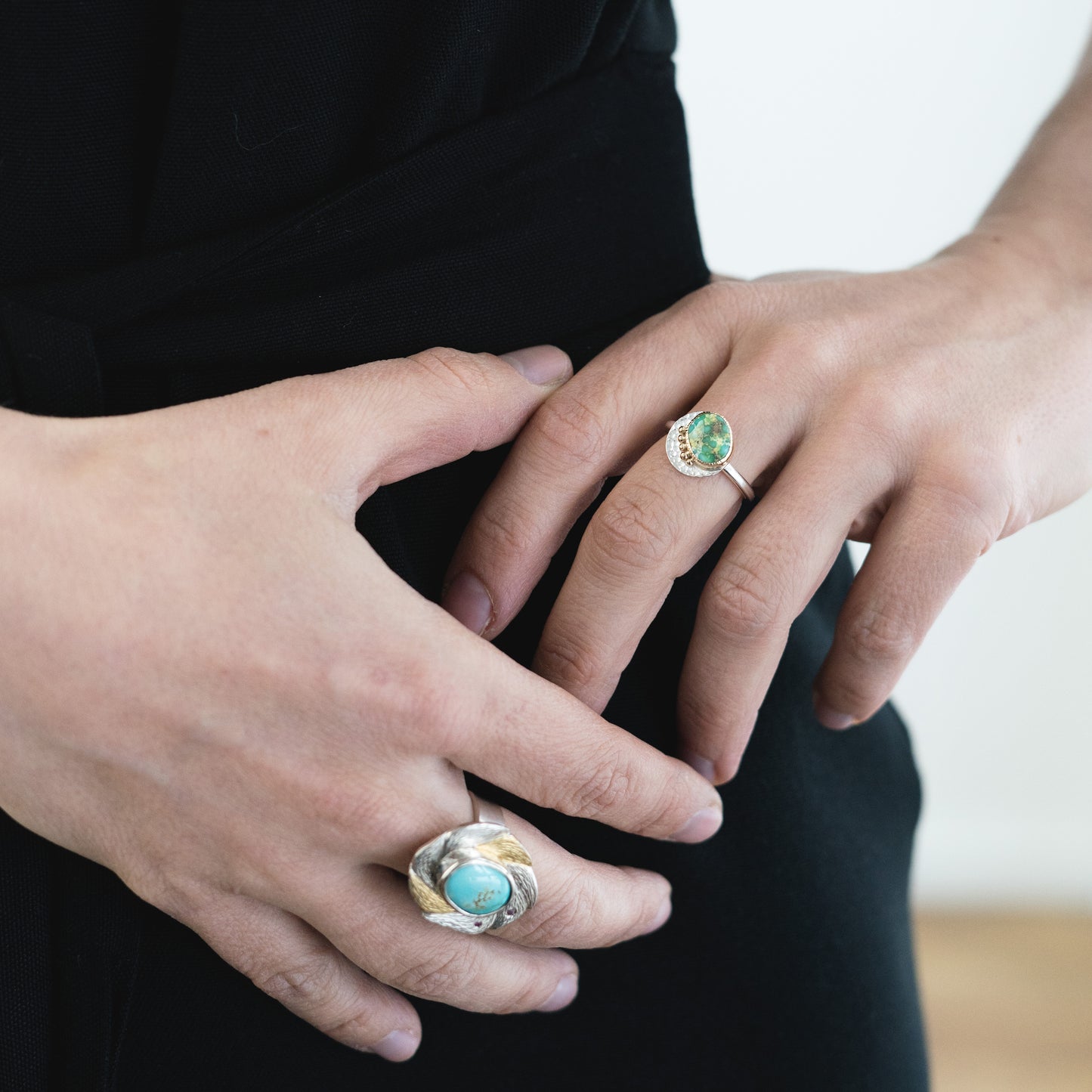 woman wearing blue and green gemstone rings